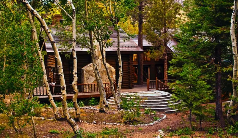 The chalet's log walls and stone steps among the aspens, room for a group of eight