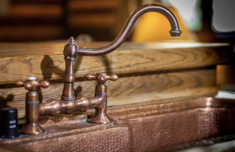 The hand-hammered copper sink and faucet at the chalet's breakfast bar, against a counter of local oak