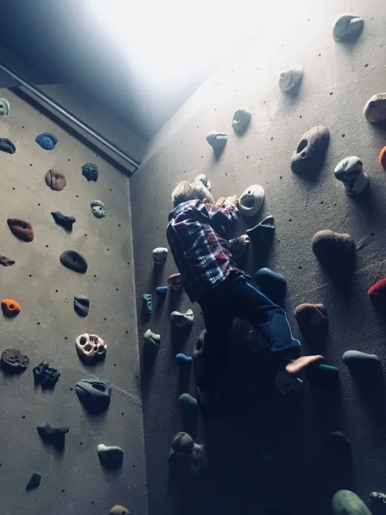 A child climbing the indoor wall in the chalet garage