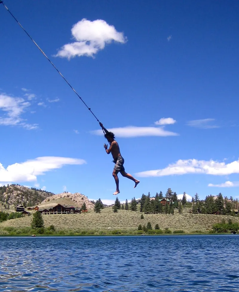 A guest swinging out over Gull Lake on a summer afternoon