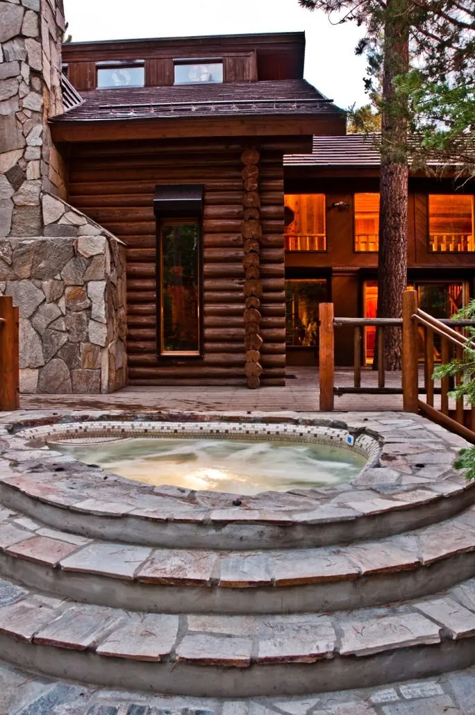 The hydrotherapy tub in its stone surround below the chalet's log walls