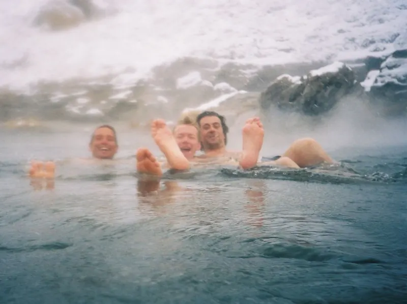 Bathers in a natural hot spring with the Sierra behind
